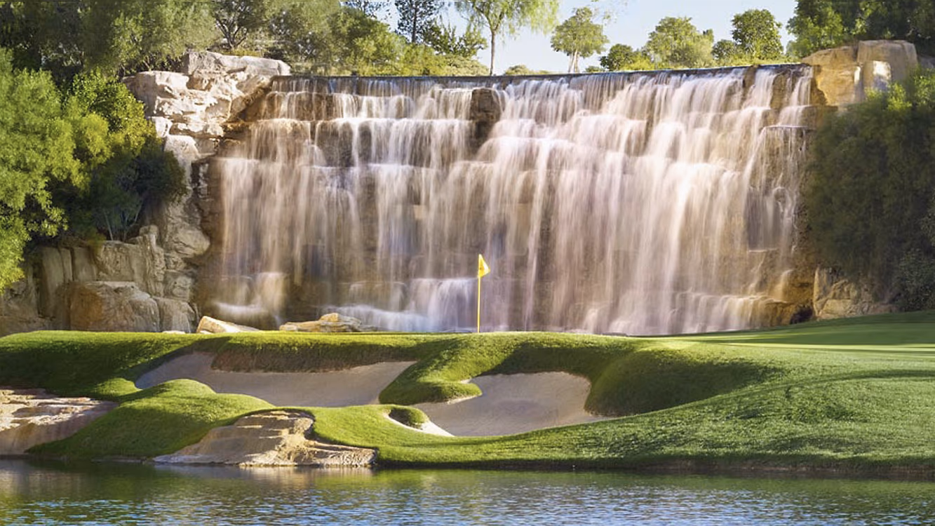 The waterfall hole at Wynn Golf Club, with a yellow pin on the green below the falls.